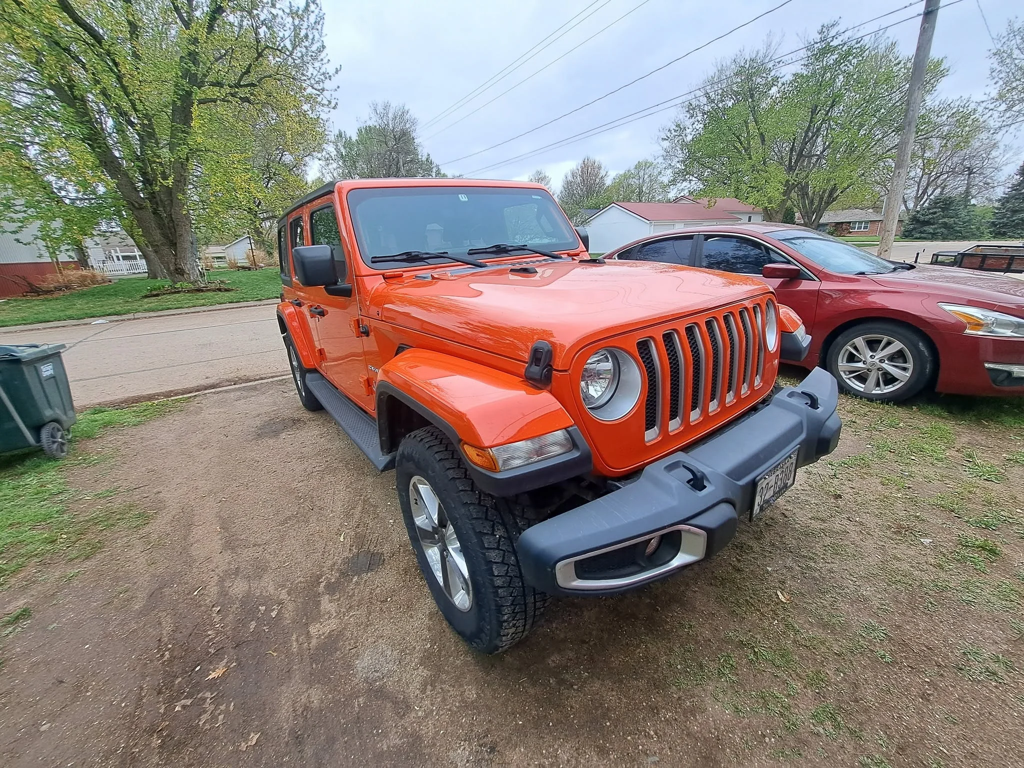 Orange Jeep Wrangler detailed, parked on the street